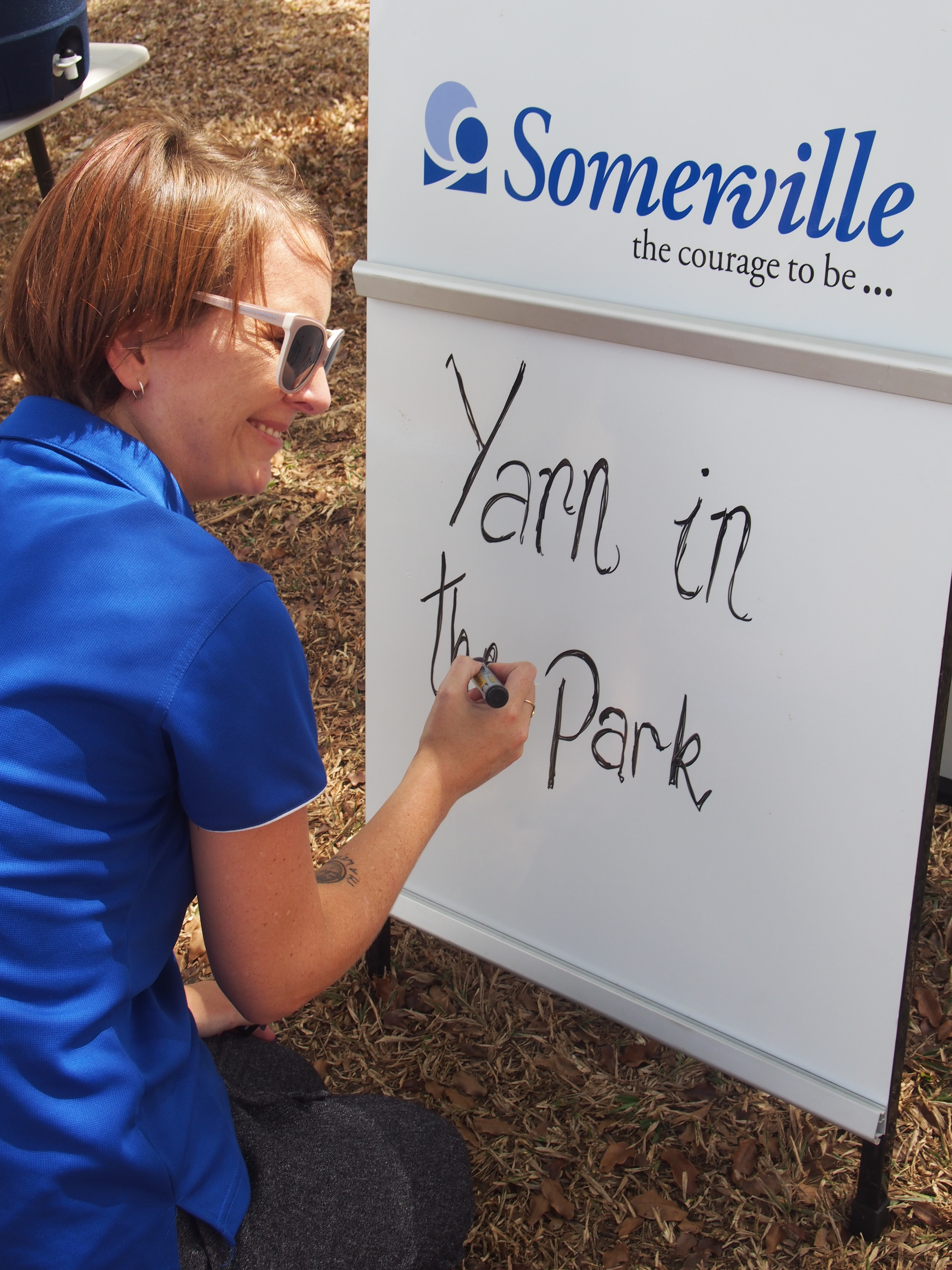 Somerville staffer writes &quot;Yarn in the Park&quot; on a whiteboard.